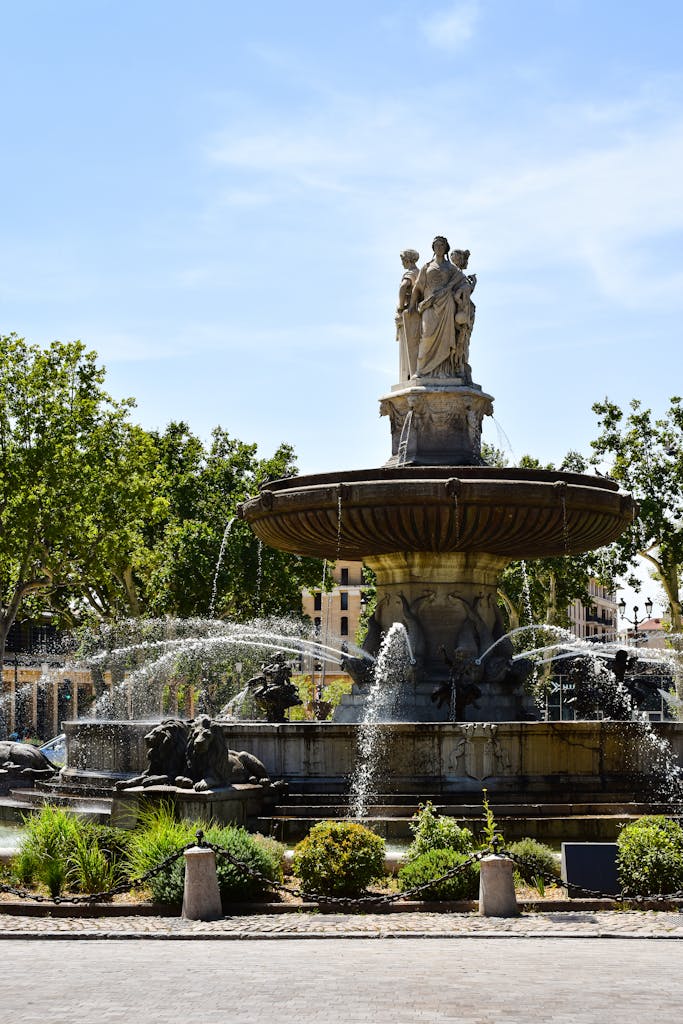 Majestic fountain at La Rotonde, a landmark in Aix-en-Provence, France, on a sunny day.
