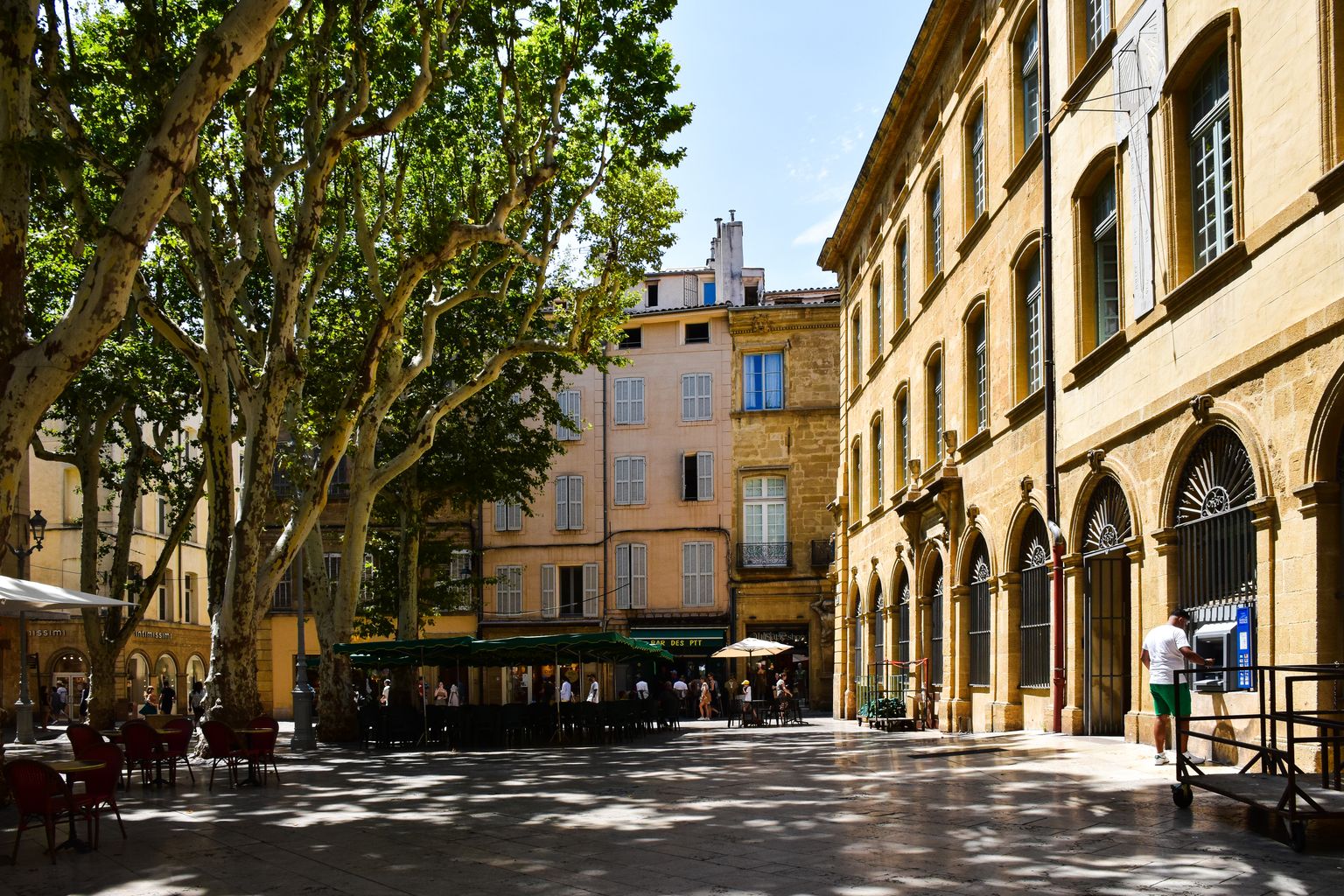 A sunny day in Aix-en-Provence showcasing historic architecture and lush trees.